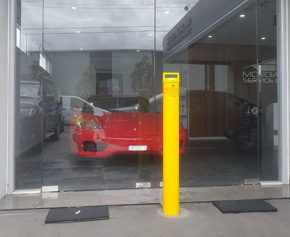 A Security Bollard in Front of a Red Sports Car